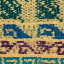 A cloth with a yellow background from bottom to top teal fretts, purple ivyu, blue waves, and green leaves motifs.