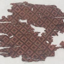 a light and dark marueen with diamond patterns and spade designs in the middle