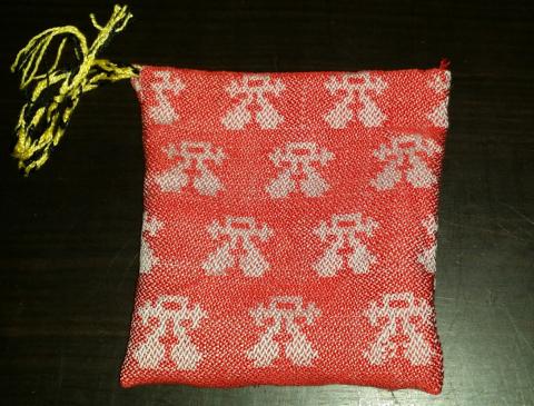 A bag made of damask fabric with a red background and grey water bugettes